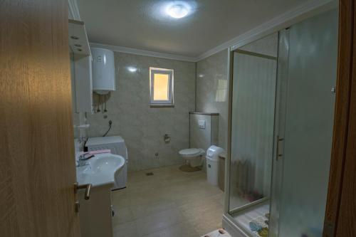 y baño con aseo, lavabo y ducha. en Apartman Vitina en Ljubuški