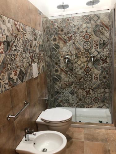 a bathroom with a toilet and a shower and a sink at B&B Meliora Rooms in Avola