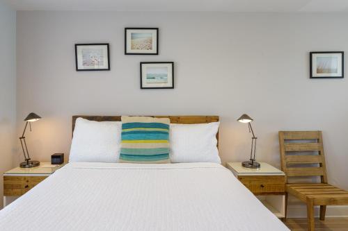 a bedroom with a white bed with two tables and two lamps at Aqualina Inn Montauk in Montauk