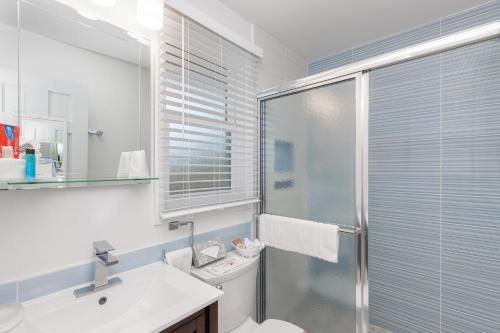 a bathroom with a shower and a toilet and a sink at Aqualina Inn Montauk in Montauk