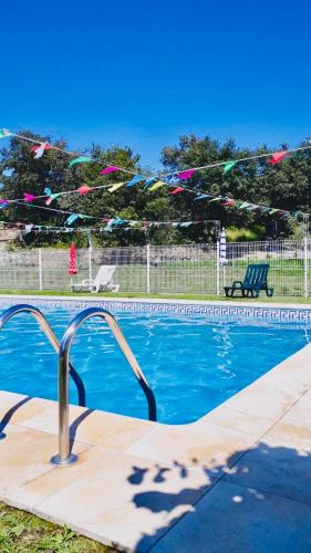 a swimming pool with colorful kites flying above it at Chambre de la tour - Quinta da Prelada Simão in Celorico de Basto