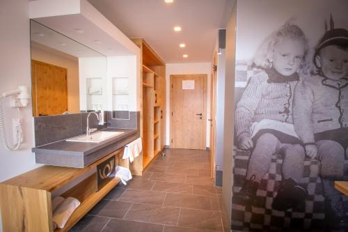a bathroom with a sink and a picture of a child on the wall at Gasthof Post in Rennweg