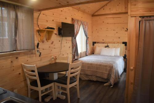 1 dormitorio con 1 cama, mesa y sillas en Drift Lodge en Island Park