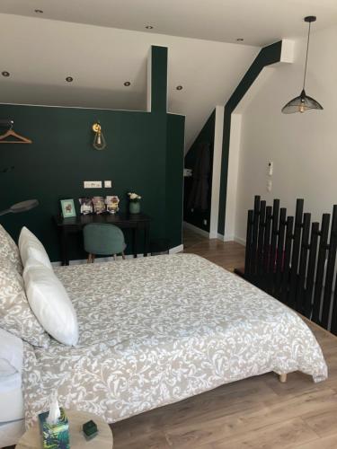 Un dormitorio con una cama grande y una pared verde en Sylina Spa avec Jacuzzi Privé, en Villeblevin