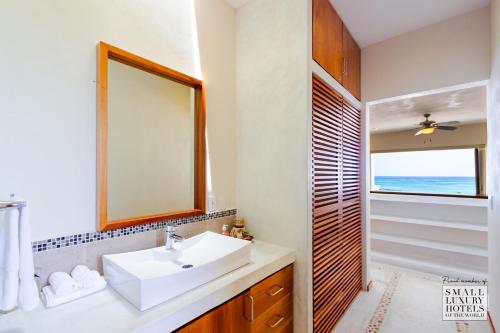 a bathroom with a sink and a mirror and a window at KASA Cooper in Akumal