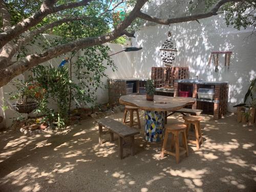 uma mesa de piquenique e bancos debaixo de uma árvore em Casa Bella Mya em Taganga