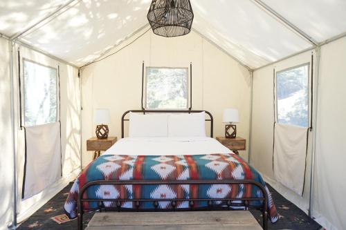 a bedroom with a bed in a tent at Shaver Lake Village Hotel in Shaver Lake