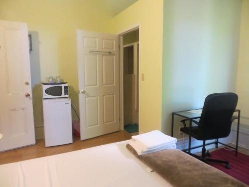 Zimmer mit einer Mikrowelle, einem Tisch und einem Stuhl in der Unterkunft Keppner Guesthouse in Toronto