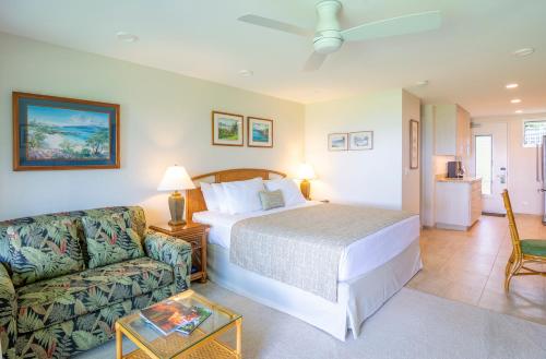 a bedroom with a bed and a couch at Nāpili Surf Beach Resort by Castle in Lahaina