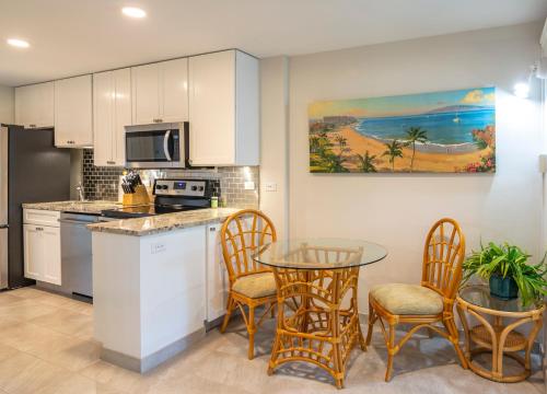 a kitchen with a table and chairs and a counter top at Nāpili Surf Beach Resort by Castle in Lahaina