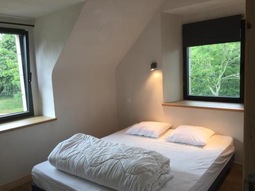 a bedroom with two beds and two windows at Les gîtes du Plec - Piscine in Locoal-Mendon