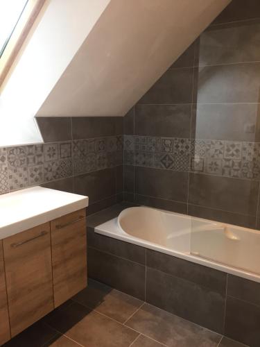 une salle de bain avec une baignoire et un lavabo dans l'établissement Les gîtes du Plec - Piscine, à Locoal-Mendon