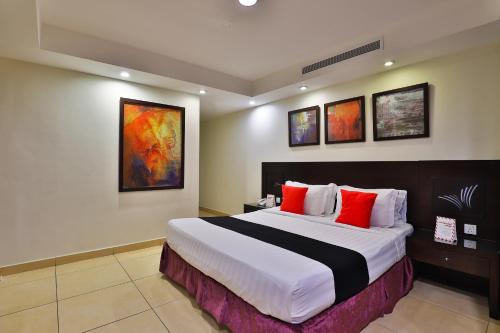 a hotel room with a large bed with red pillows at أحلى الأيام للوحدات الفندقية in Jeddah