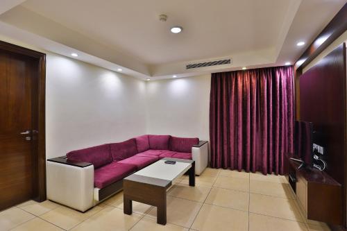a living room with a purple couch and a table at أحلى الأيام للوحدات الفندقية in Jeddah