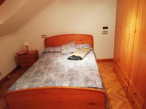 a bedroom with a bed with a wooden bed frame at Duplex Álvaro cunqueiro, 1.3C1 in Foz