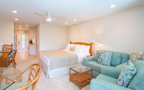 a hotel room with a bed and a couch and a table at Nāpili Surf Beach Resort by Castle in Lahaina
