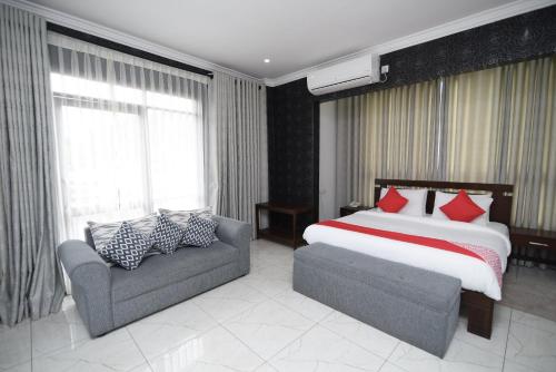 a bedroom with a bed and a couch and a bed and window at Galaxy City Hotel in Kandy