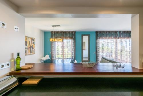 una sala da pranzo con tavolo in legno e 2 finestre di Mar da Luz Terrace Apt 118 a Lagos