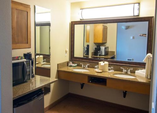 a bathroom with two sinks and a large mirror at Overleaf Lodge and Spa in Yachats