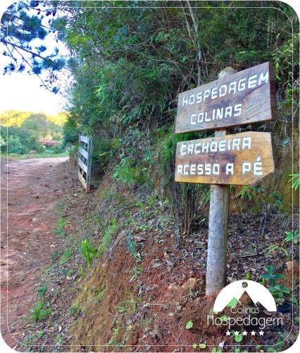 a sign on the side of a dirt road at Hospedagem Colinas in Aiuruoca
