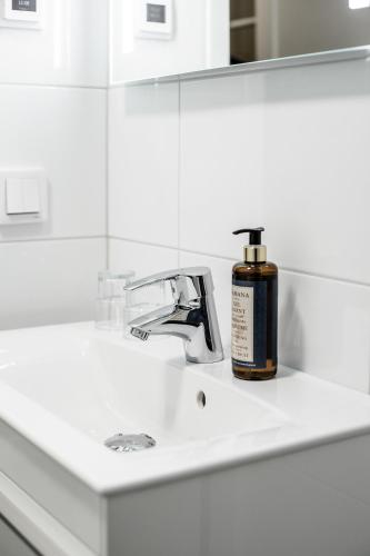 a bottle of soap sitting on a bathroom sink at Piteå Stadshotell in Piteå