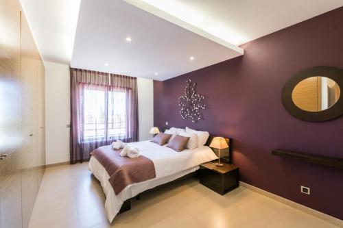 um quarto com uma cama grande e uma parede roxa em Mar da Luz Terrace em Lagos