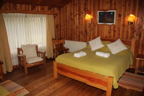 a bedroom with a bed with two towels on it at Hosteria-Cabañas Rucapillan in Choshuenco