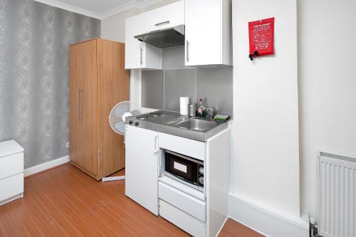 a small kitchen with a sink and a stove at Flexistay Tulsi Aparthotel in Croydon