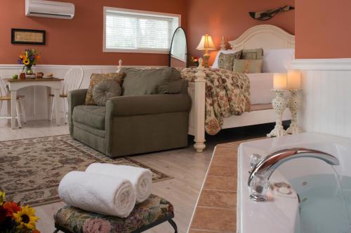 a bedroom with a bed and a couch and a sink at 1825 Inn Bed and Breakfast in Palmyra