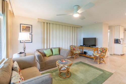 a living room with a couch and a tv at Nāpili Surf Beach Resort by Castle in Lahaina