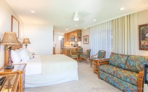 a hotel room with a bed and a couch at Nāpili Surf Beach Resort by Castle in Lahaina