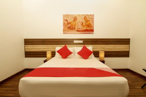 a bedroom with a large white bed with red pillows at Clove Transit Hotel in Kotugoda