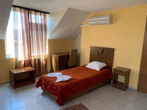 um quarto de hotel com uma cama e uma janela em ALPHA family HOTEL em Blagoevgrad