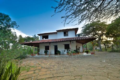a small white house with a roof at Posada Villa Paula in Barichara