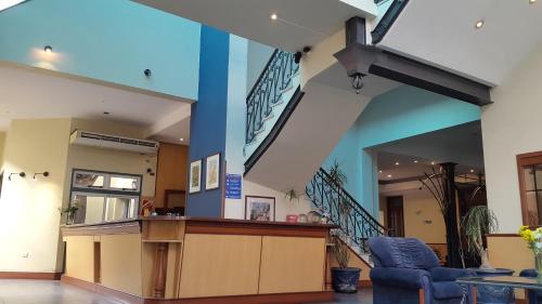 a lobby with a counter and stairs in a building at Hotel Plaza Rafaela in Rafaela