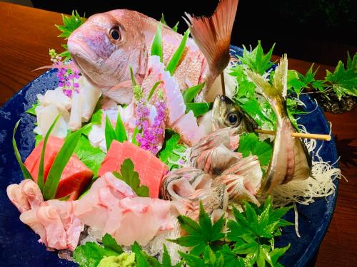 a plate of food with a fish and seafood at Balinese onsen ryokan Hakone Airu in Hakone