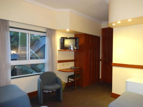 a room with a bed and a desk and a window at Hotel Plaza Rafaela in Rafaela