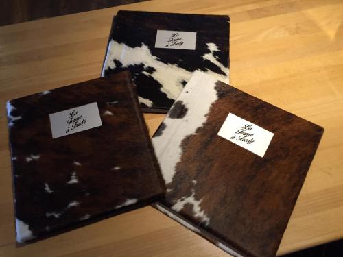 two brown and white notebooks sitting on top of a table at Hôtel Le Grand Chalet in Leysin
