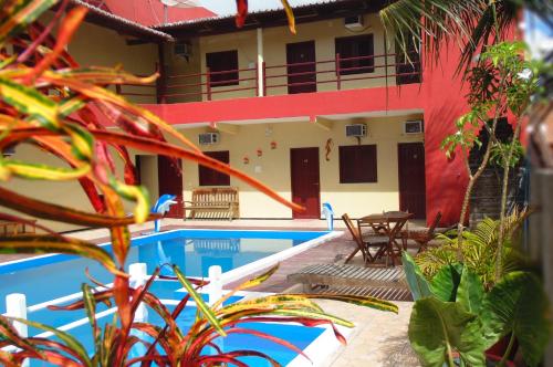 a resort with a swimming pool and a house at Pousada Vital in Jericoacoara
