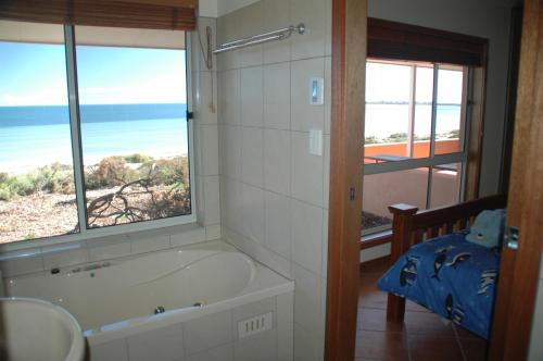 a bathroom with a tub with a view of the ocean at Ceduna Shelly Beach Caravan Park in Ceduna