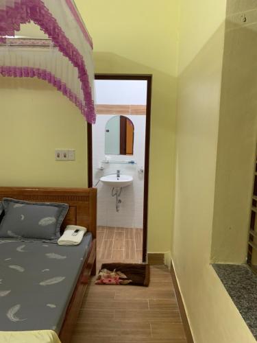 a bedroom with a bed and a bathroom with a sink at Khuổi Ky Eco Homestay in Cao Bằng