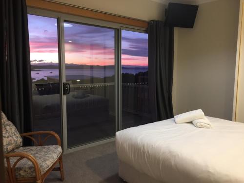- une chambre avec un lit et une fenêtre donnant sur le coucher du soleil dans l'établissement White Sands Estate unit 20, à Four Mile Creek