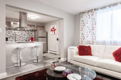 een woonkamer met een witte bank en een keuken bij ENTIRE 2 BEDROOM APARTMENT UPTOWN WATERLOO - e1 in Waterloo