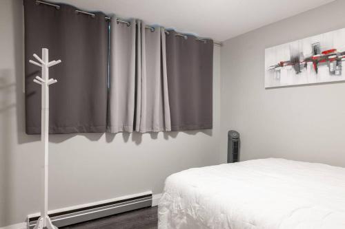 a bedroom with a bed and a cross on the wall at ENTIRE 2 BEDROOM APARTMENT UPTOWN WATERLOO - e1 in Waterloo