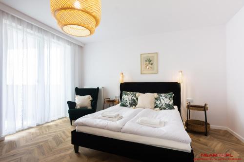 sypialnia z dużym łóżkiem i krzesłem w obiekcie Apartments Nearto Old Town Vermelo w Krakowie