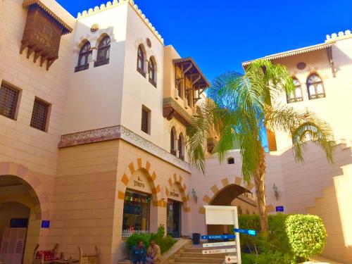a building with a palm tree in front of it at Luxury Villa with pool in Hurghada in Hurghada