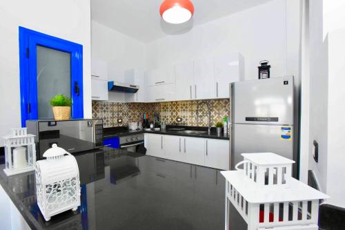 a kitchen with white cabinets and a stainless steel refrigerator at Luxury Villa with pool in Hurghada in Hurghada