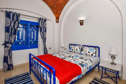 a bedroom with a blue and white bed and a window at Luxury Villa with pool in Hurghada in Hurghada