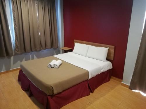 um quarto com uma cama com um par de controladores em Grandpa Hotel em Port Dickson