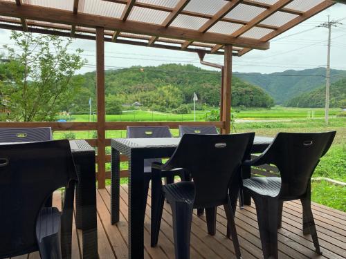 einen Tisch und Stühle auf einer Terrasse mit Aussicht in der Unterkunft 無鹿リゾート in Kokuryō